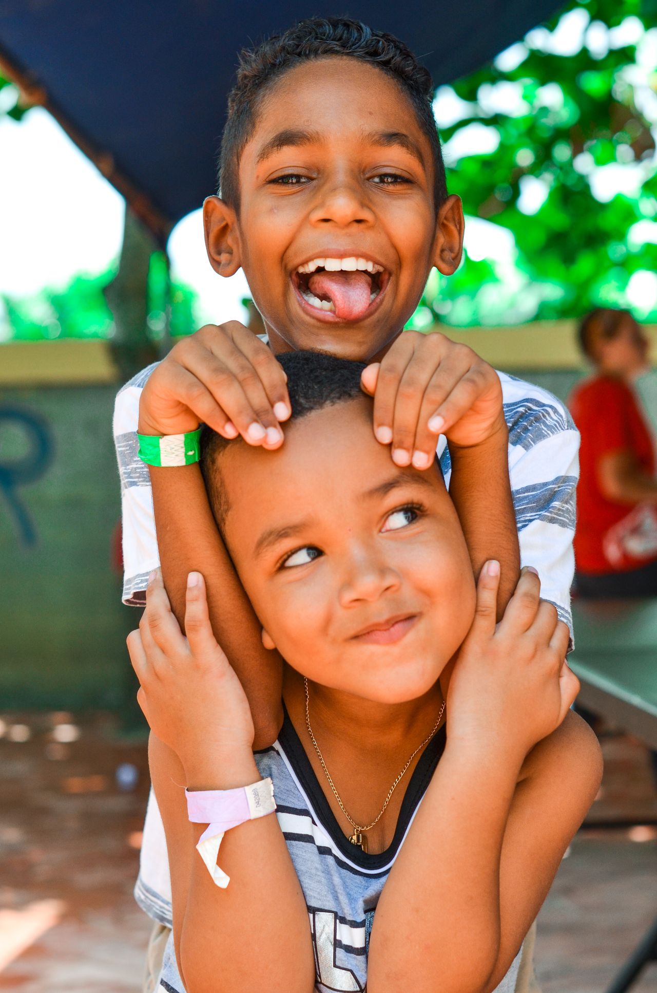 Two smiling boys enjoying time outdoors in the Dominican Republic, representing the joy of O Faro's community